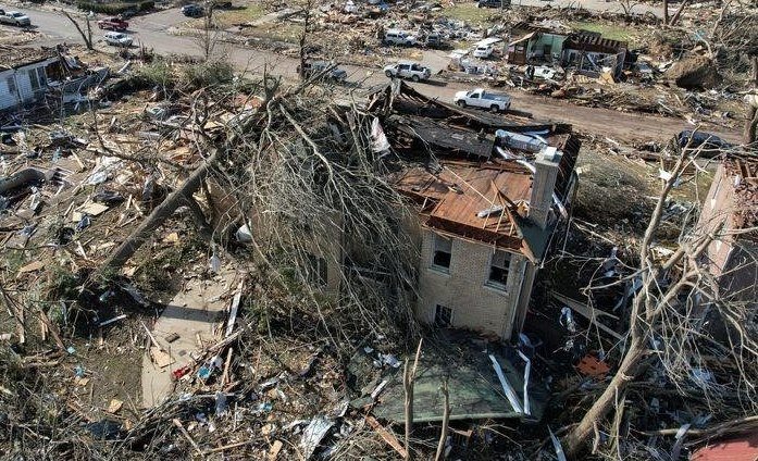 Выжившие после разрушительных торнадо в Кентукки разбирают завалы в своих обрушившихся домах.